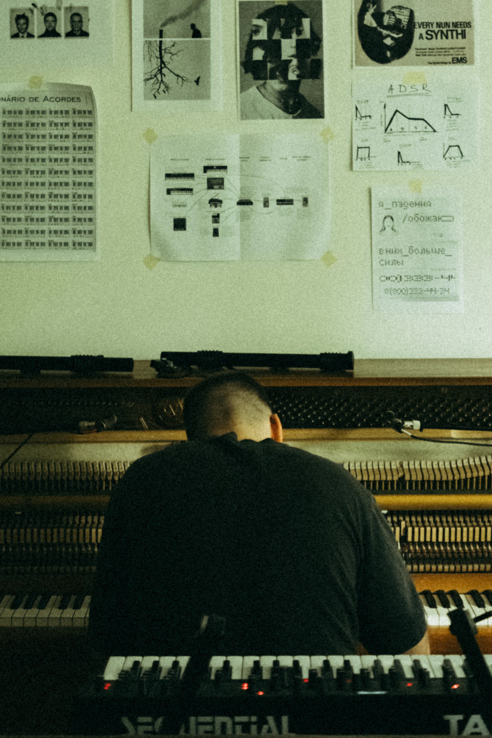 Musicista di spalle davanti a un synth in studio
